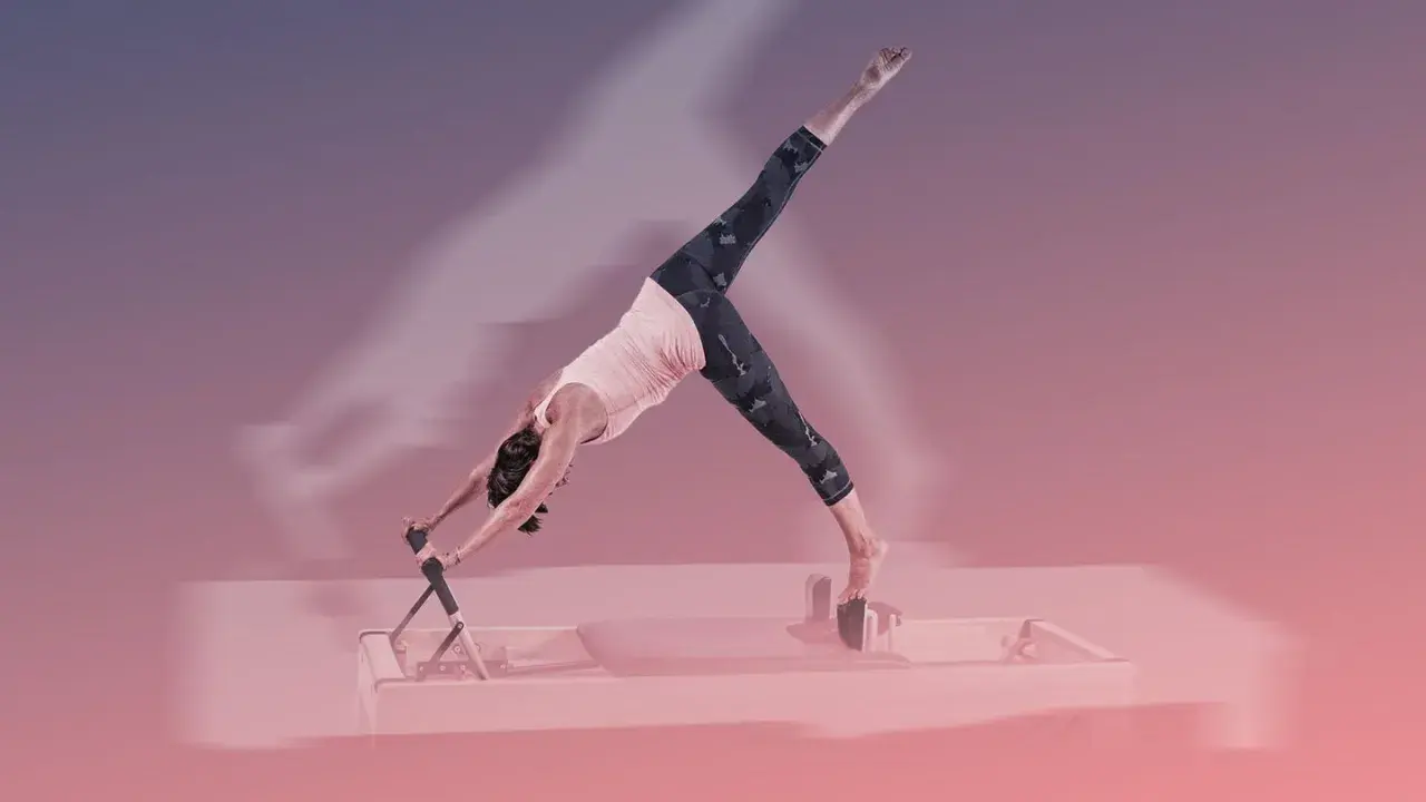 Frau in der Pose "Herabschauender Hund" auf einem Reformer Pilates Gerät.