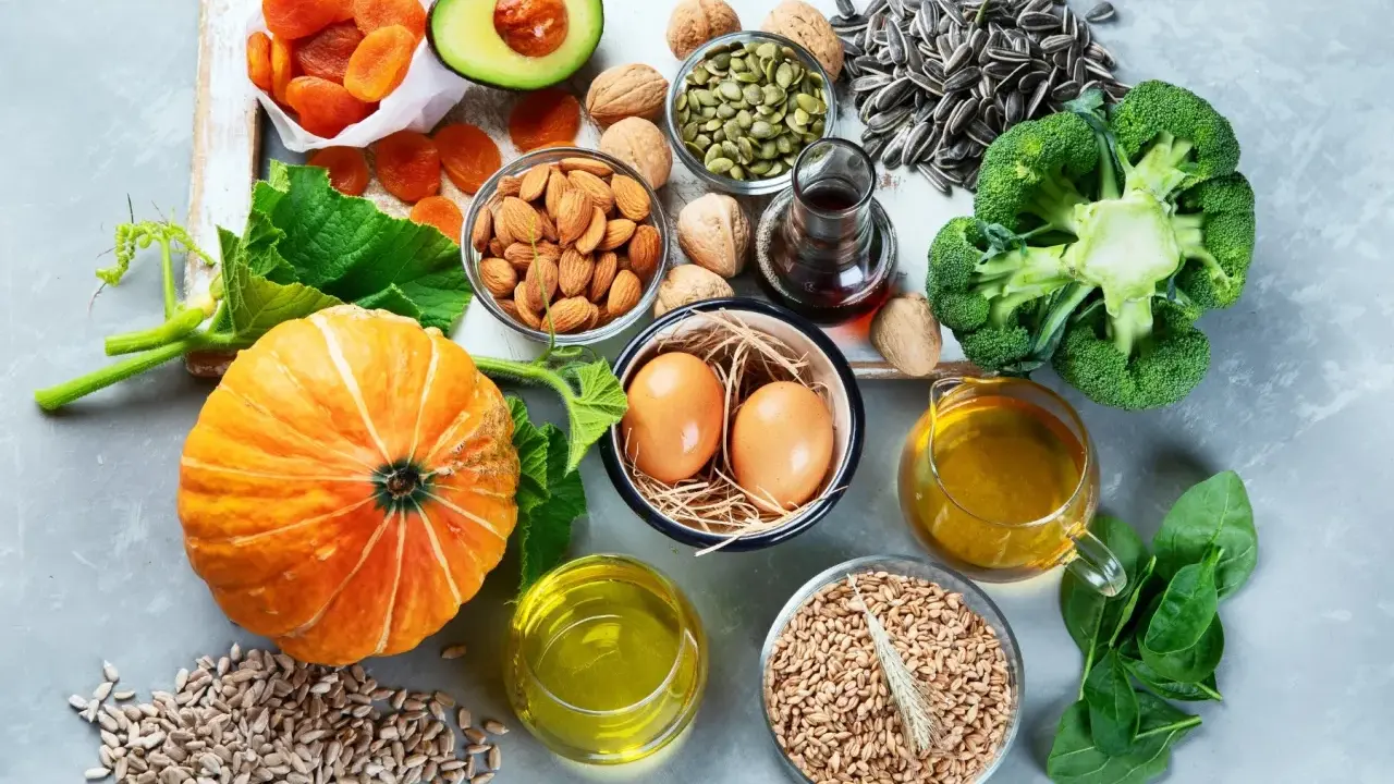 Vielfalt an vitamin e lebensmittel: Kürbis, Avocado, Mandeln, Sonnenblumenkerne, Brokkoli, Spinat, Eier und Öle.