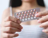 Frau hält Blisterpackung mit Pillen. Bei der Entscheidung, die Pille durchzunehmen, sind Nebenwirkungen zu beachten.