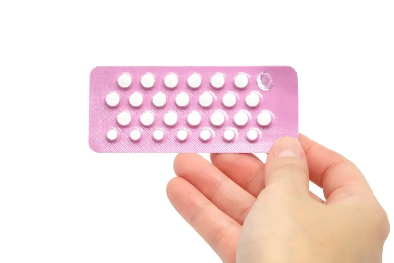 Hand hält eine Packung mit weißen Pillen. Fragen wie 