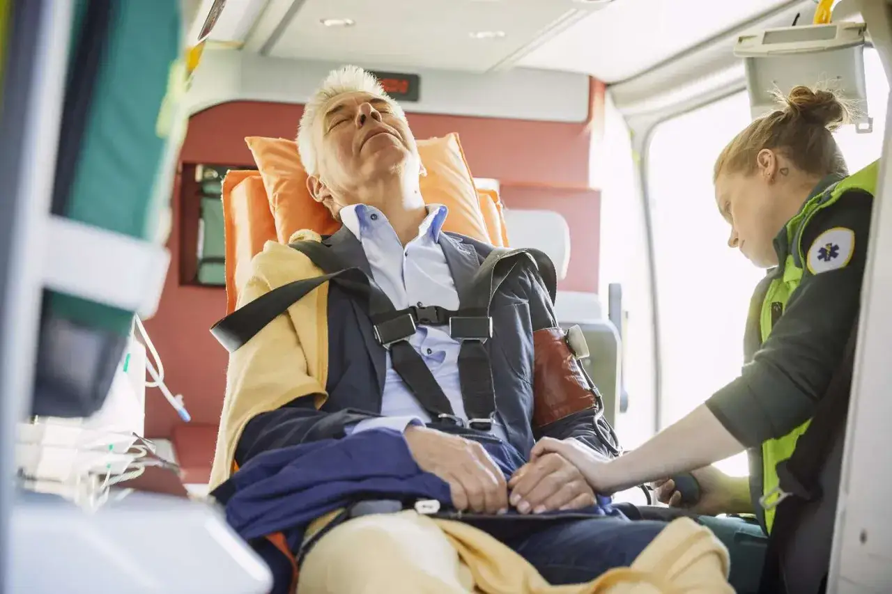 Sanit&auml;terin gibt einem Mann im Krankenwagen ein Notfallmedikament bei Schlaganfall.