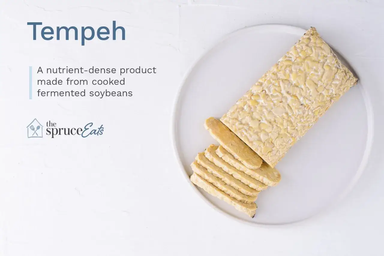Ein Block Tempeh, geschnitten, auf einem Teller. Tempeh ist ein nährstoffreiches Produkt aus gekochten, fermentierten Sojabohnen.