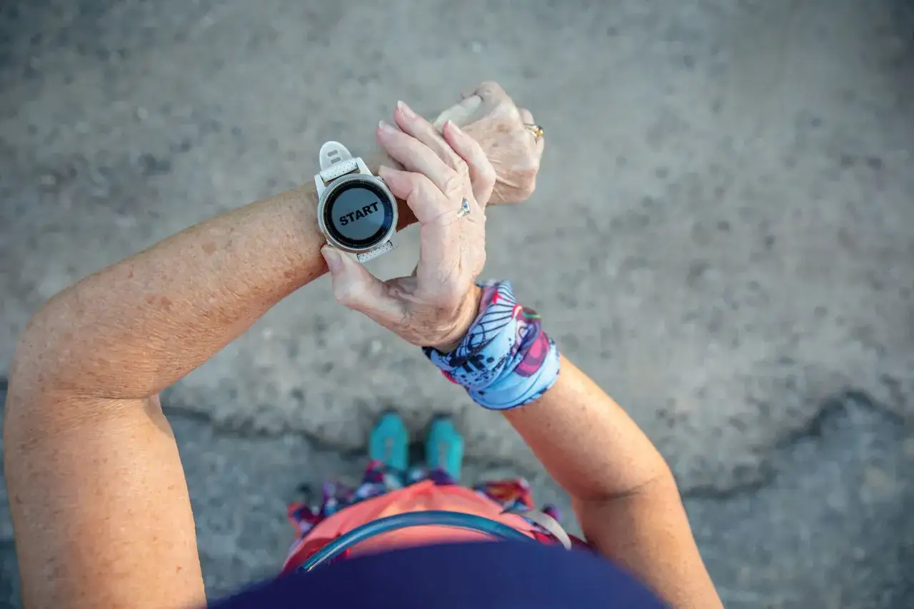 Eine Frau pr&uuml;ft ihre Smartwatch, bereit, ihre t&auml;glichen Schritte zu z&auml;hlen.