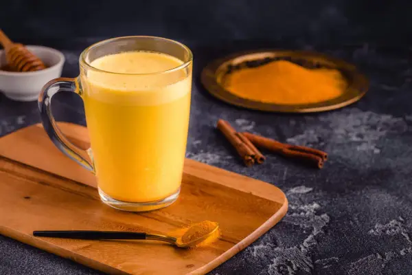 Goldene Milch mit Kurkuma, Zimt und Honig. Die goldene Milch Wirkung ist bekannt für ihre entzündungshemmenden Eigenschaften.